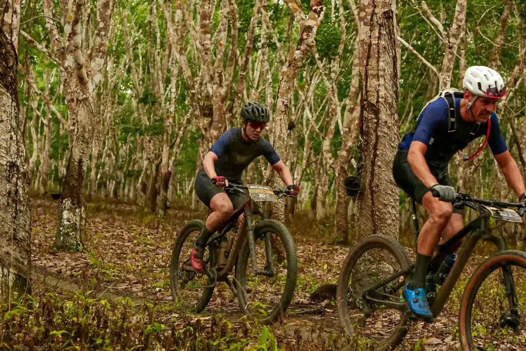 Mixed mountain bike team riding trough jungle